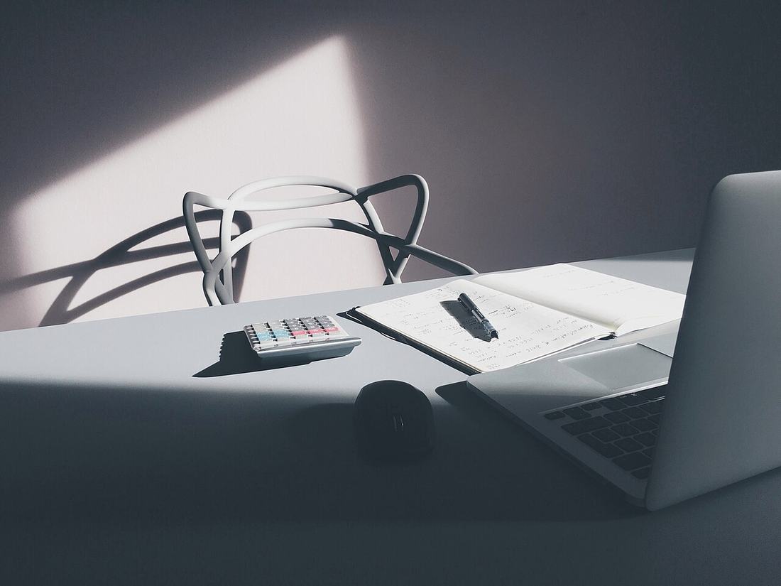 A desk with a laptop and calculator
